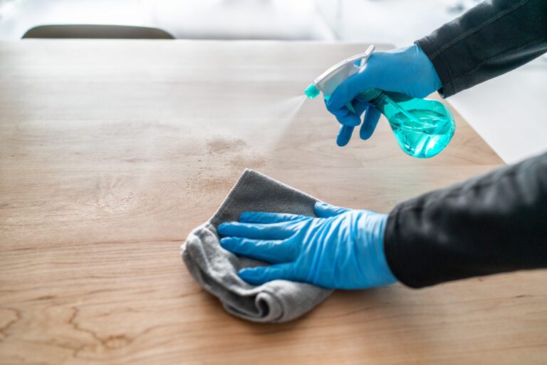 wiping a table with spray and cloth